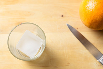 Glass, orange and knife on a cutting board
