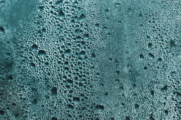 Texture of raindrops on a misted glass. Color turquoise.