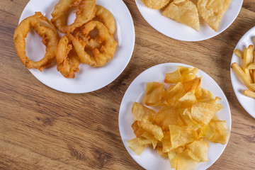 Mixed fried snacks on the table. French fries, onion rings and fries