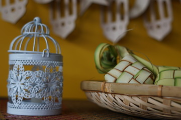 Traditional lamp and ketupat on Asian textured background