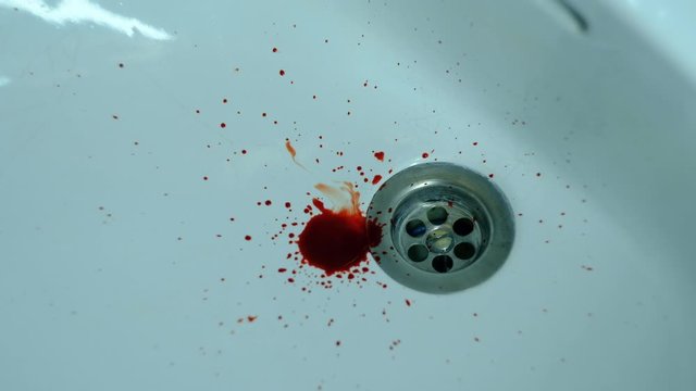Dark blood dripping on a white washbasin