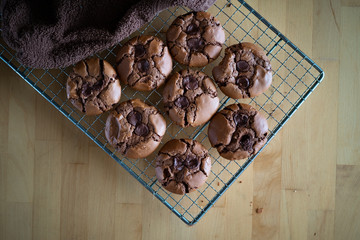 soft dark chocolate brownie cookies on a metal rack on a wooden background.