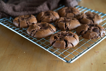 soft dark chocolate brownie cookies on a metal rack on a wooden background.