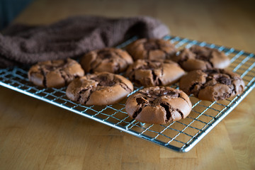 soft dark chocolate brownie cookies on a metal rack on a wooden background.