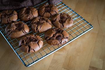 soft dark chocolate brownie cookies on a metal rack on a wooden background.