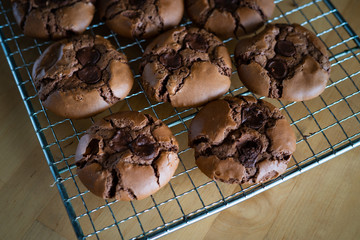 soft dark chocolate brownie cookies on a metal rack on a wooden background.