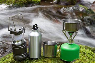 沢をバックに苔の上のキャンプ用品