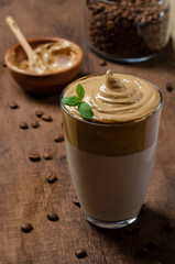 Dalgona Coffee Iced, a Korean whipped black instant coffee with milk, on a dark background