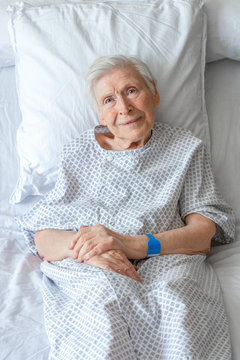 Personne &acirc;g&eacute;e sur lit d'h&ocirc;pital, souriante