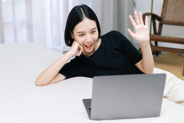 Attractive asian female conference with co-worker using computer laptop at home. Work from home concept.