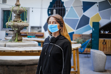 Latin girl wearing face mask for social distancing in new normal situation protecting and...