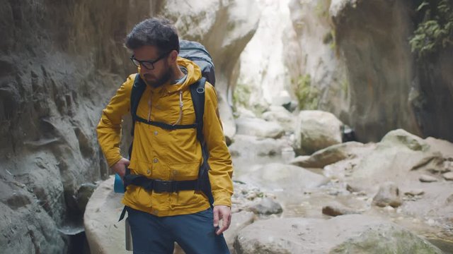 Lost traveler reading map standing in rocky canyon
