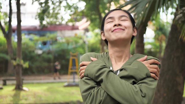 Slow motion young asian woman giving a hug, love yourself concept.