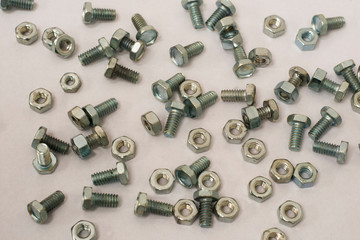 A lot of bolts and nuts on a withe background.