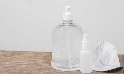 The white sanitizer gel in the bottle and masks to prevent germs, viruses, bacteria, and Coronavirus. 