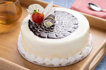 Chocolate mousse cake with strawberry and grated white chocolate topping with a Whipped cream border