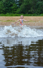 The girl runs into the water to swim.