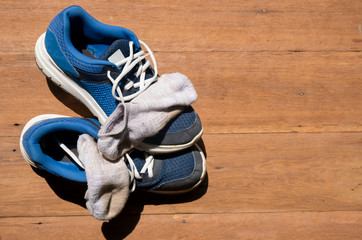 Sport shoes and socks put on a wooden floor at home  after coming back from morning jogging....