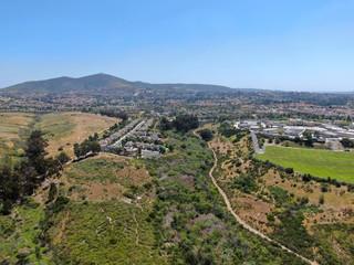 Fototapeta na wymiar Aerial view of upper middle class neighborhood with residential houses in green valley, South California, USA.