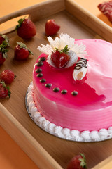 Strawberry mouse cake with a chocolate chip topping with a strawberry and grated white chocolate topping, nice strawberry colored cake