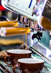 Espresso Machine pouring fresh coffee into cups at Local Coffee Shop..