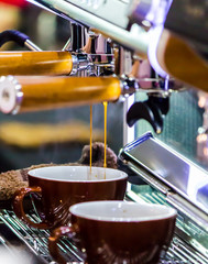 Fototapeta na wymiar Espresso Machine pouring fresh coffee into cups at Local Coffee Shop..