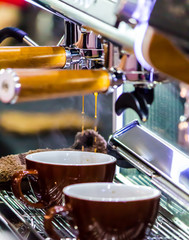 Espresso Machine pouring fresh coffee into cups at Local Coffee Shop..