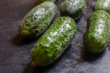 Fresh fragrant cucumbers on a dark table.