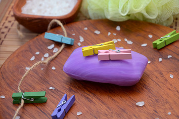 purple soap and clothespins on a wooden background