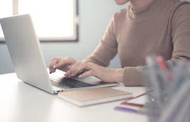 businesswoman working on white desk with laptop, smartphone at office look very busy. work from home concept