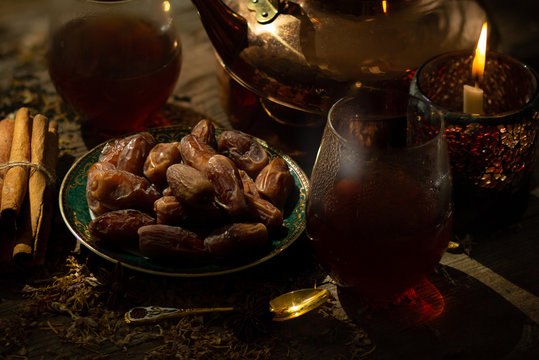 Still life image of date fruit with herbs tea.