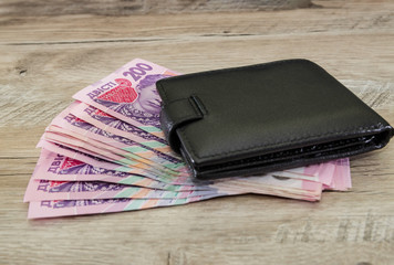 men's wallet and 200 hryvnia on a wooden table.Business concept.