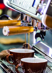 Espresso Machine pouring fresh coffee into cups at Local Coffee Shop..