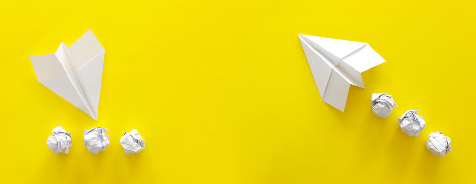 concept image of crisis and opportunity . one paper plane taking off while the second is crashing. yellow background
