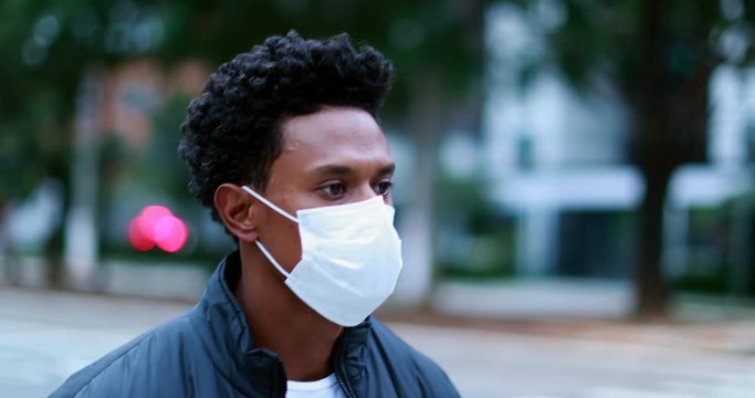 African American man walking in city downtown wearing surgical face mask prevention against outbreak pandemic