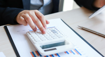 Accounting businessmen are calculating income-expenditure and analyzing real estate investment data, Dedicated to the progress and growth of the company, Financial and tax systems concept.