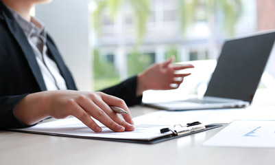 Financial or accounting professionals use a computer to analyze the company's revenue graph to prepare for presentation to the chief executive and partner, businessmen working in the room concept.