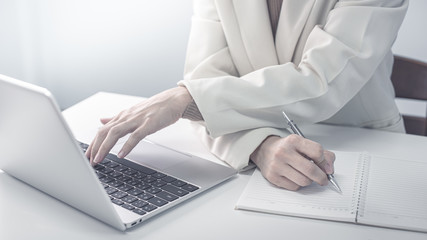 businesswoman working on white desk with laptop, smartphone at office look very busy. work from home concept