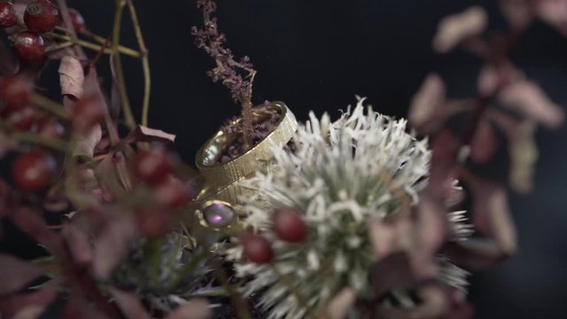 Goldene Eheringe auf Blumenstrau&szlig; in Zeitlupe