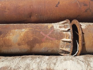 old rusty metal pipes abandoned with red crossed spay on