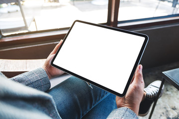 Mockup image of a woman holding black tablet pc with blank white desktop screen
