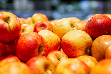 Fresh red-yellow apples on a counter in a supermarket. Healthy eating and vegetarianism. Close-up.