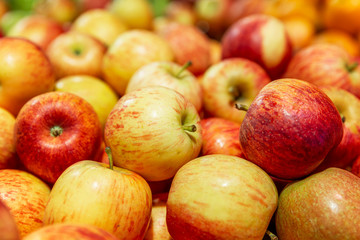 Fresh red-yellow apples on a counter in a supermarket. Healthy eating and vegetarianism. Close-up.