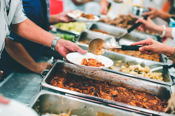 Homeless people receive free charity food from the hands of volunteers : concept of hunger problems