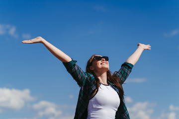 Well being, freedom, success. Happy woman with open arms in the air. Cheerful woman rising hands to blue sky. - obrazy, fototapety, plakaty