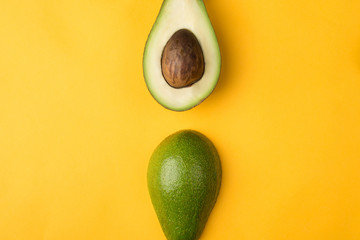 Top above overhead view photo of cut avocado placed in the center isolated on yellow background