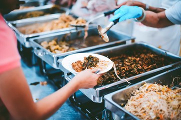 The hands of the poor have been begging to donate food from the donor, The concept of feeding