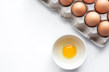 closeup of fresh chicken egg on egg box, panel, on white background with one fragile egg shell for cook for food of meal and fresh and natural egg in bowl