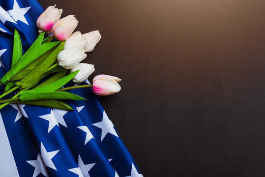Happy Memorial Day Remember previously but now seldom called Decoration Day, American flag and a Tulip flower on a black background and copy space, a federal holiday in the United States
