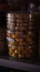 Stack of dried cookies in a plastic container in a cake shop. poor light photo